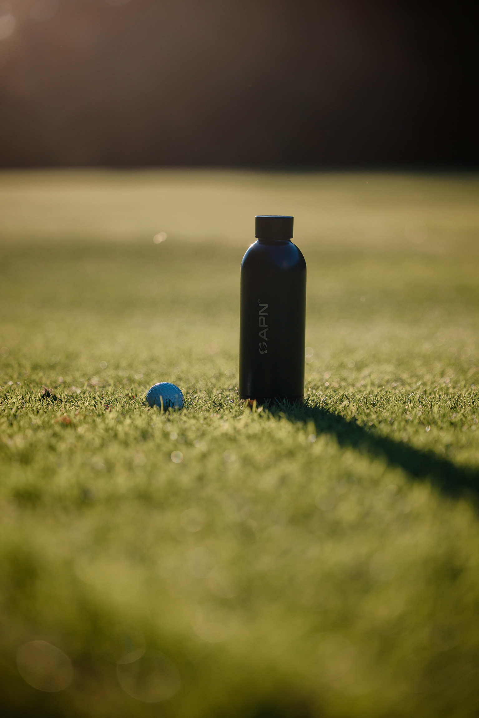APN Water Bottle - Bottle with golf ball on grass
