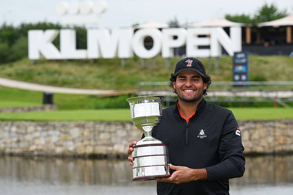 Eugenio Chacarra holding the KLM Open trophy in front of the KLM Open sign