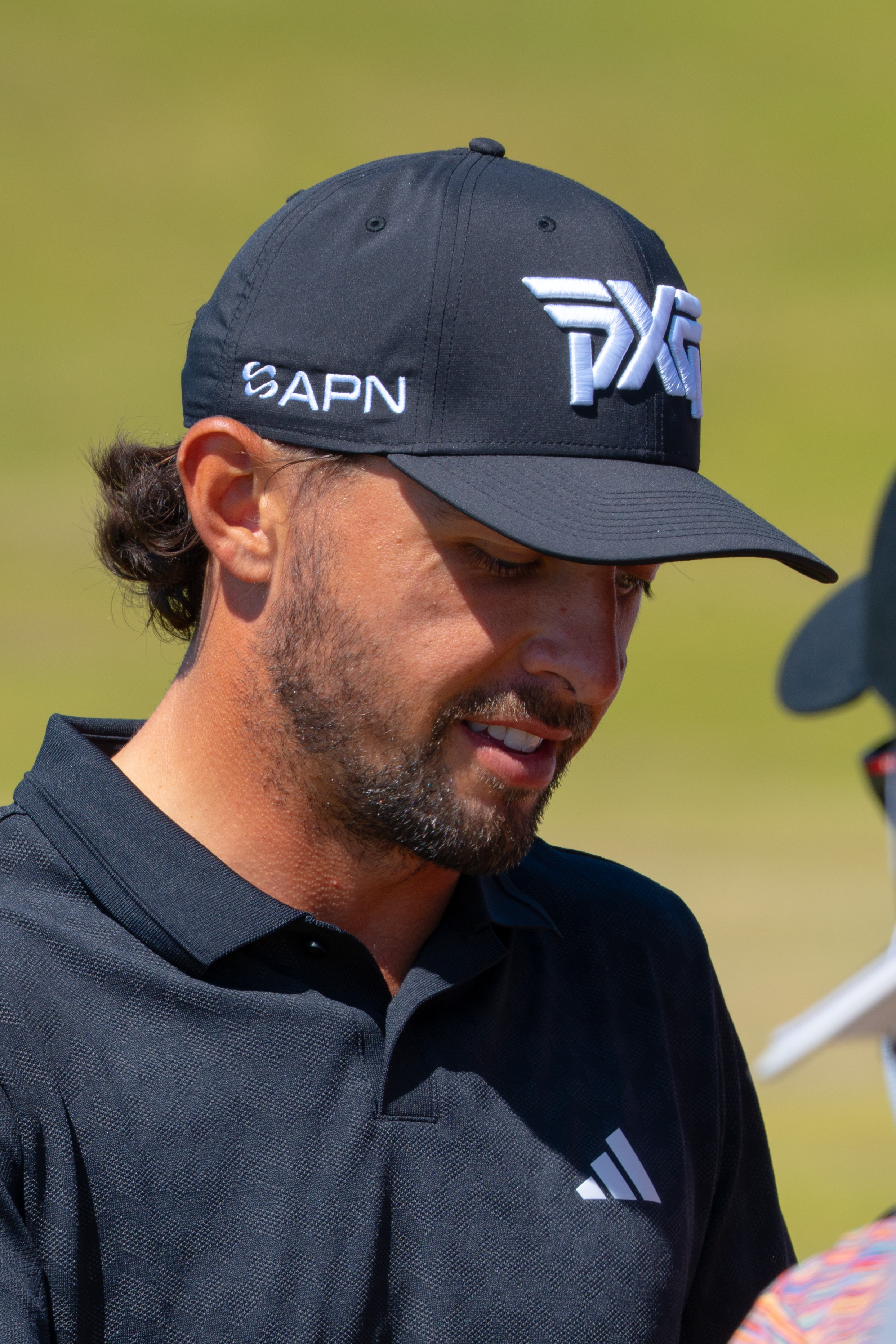 Marco Penge wearing an APN-branded cap