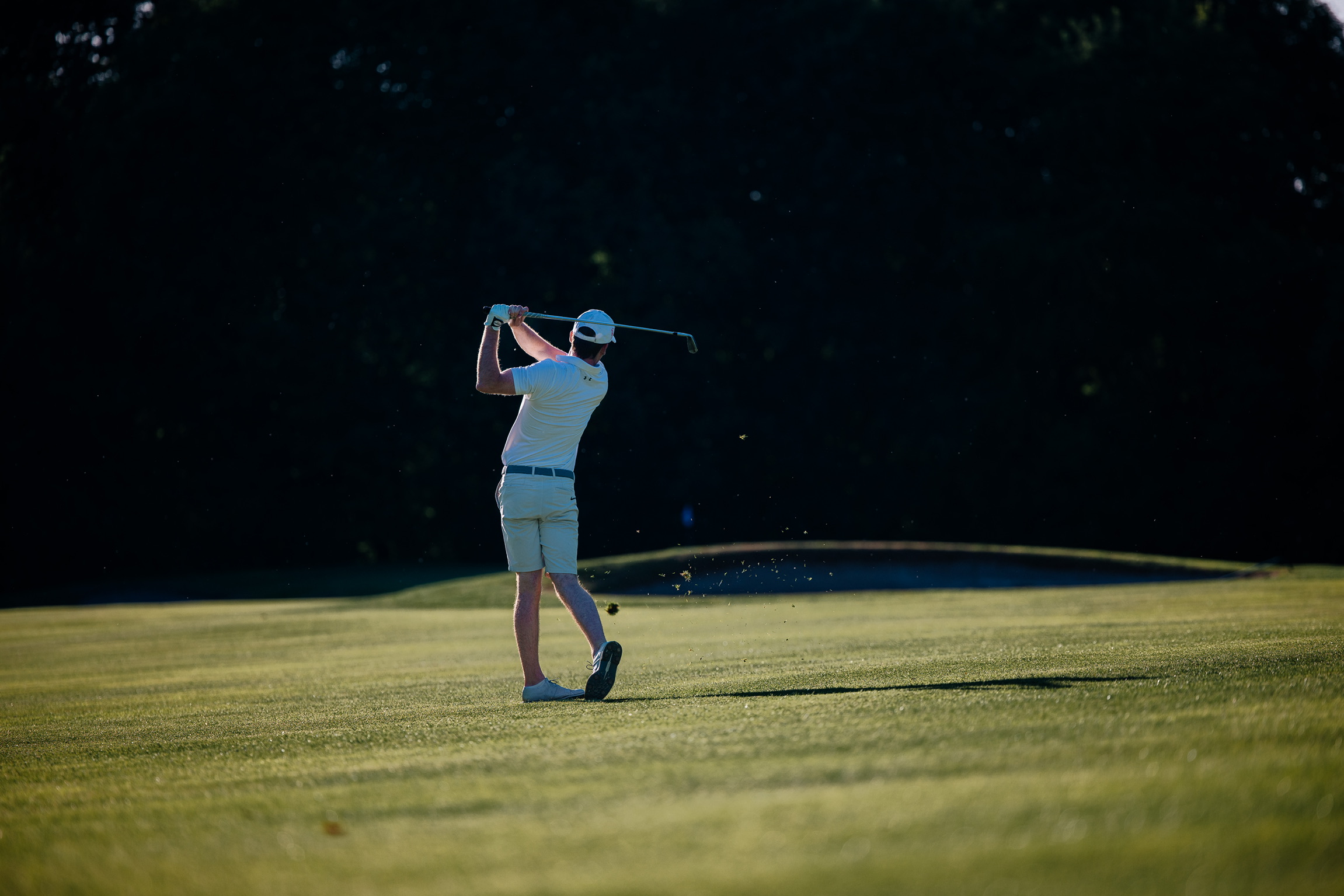 Golfer mid-swing on course