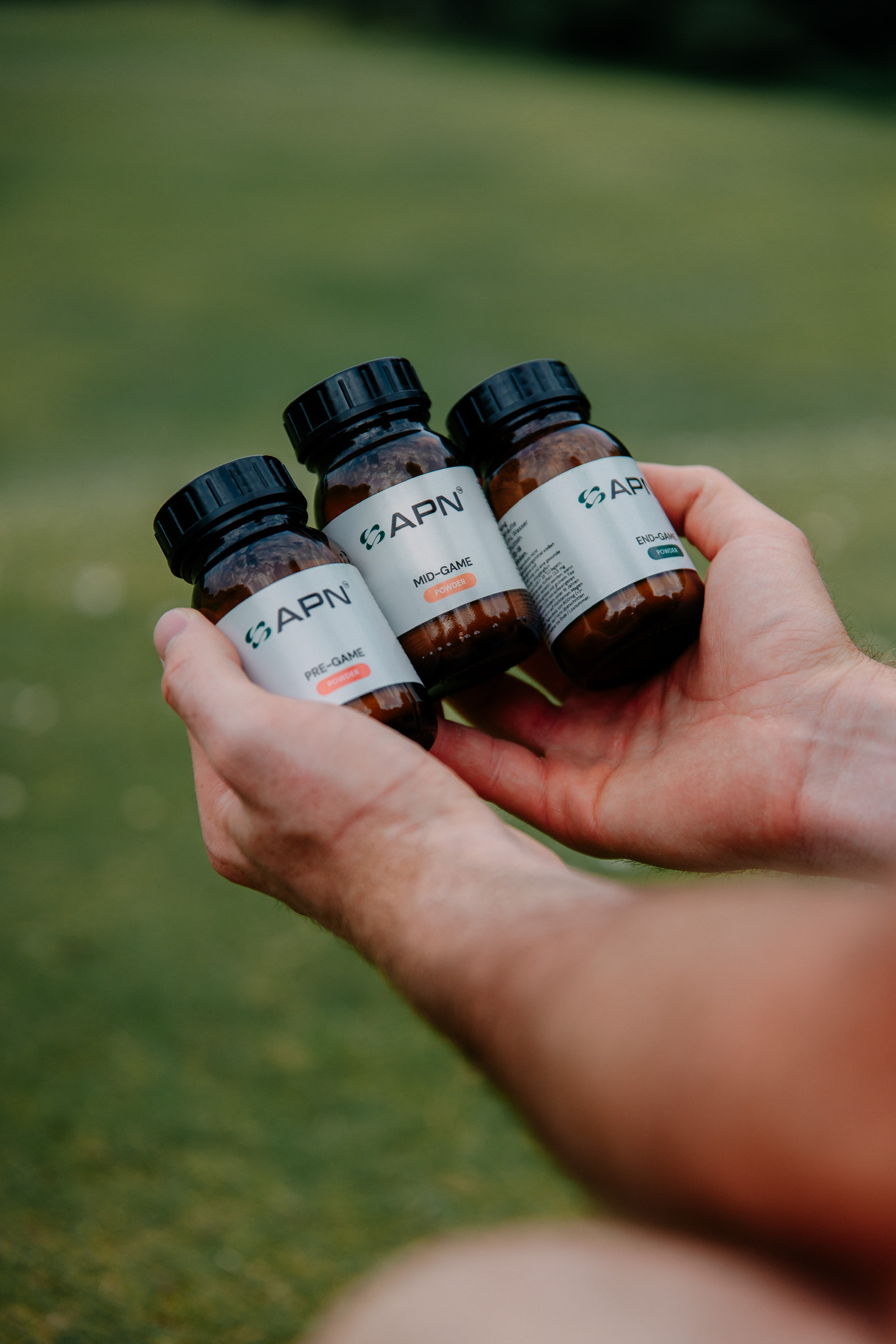 APN FUEL Set - Hand holding three bottles on golf course